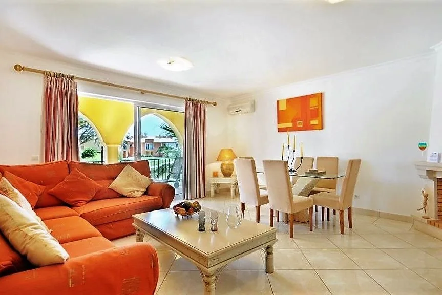 Sala de estar e jantar renovada com sofás vermelhos no Jardim da Meia Praia