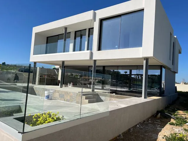 Moradia em obra em Porto de Mós, com fachada envidraçada e terraço junto à piscina
