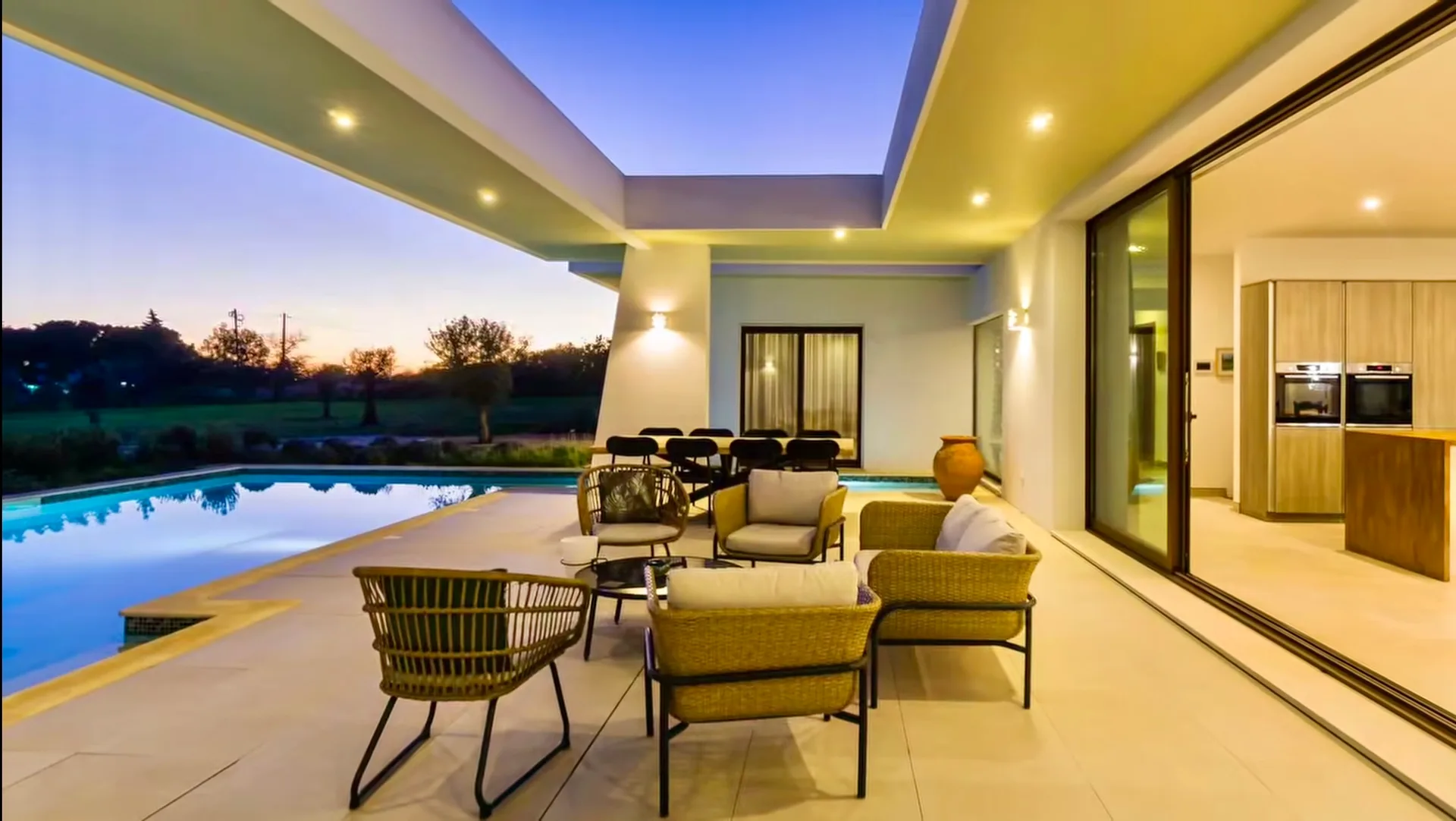 Zona de estar coberta junto à piscina da Villa Porches ao pôr do sol